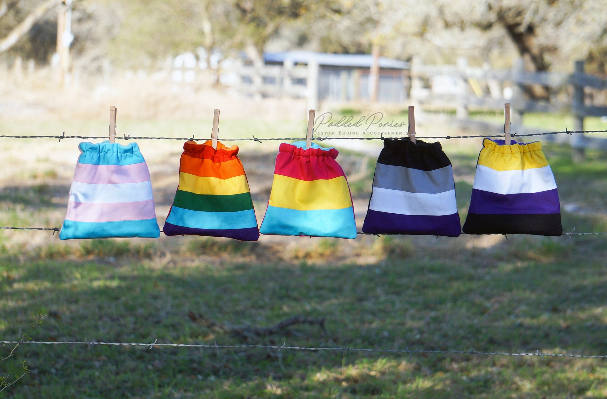 LGBTQ+ Flag stirrup covers clipped to a fence line